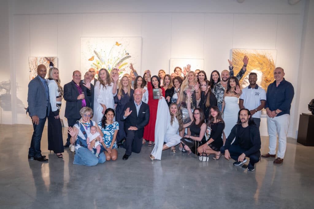 Group photo at The Mother Earth Effect book launch event at The Wall Art Gallery in Wynwood, Miami, featuring attendees celebrating art, community, and wellness.
